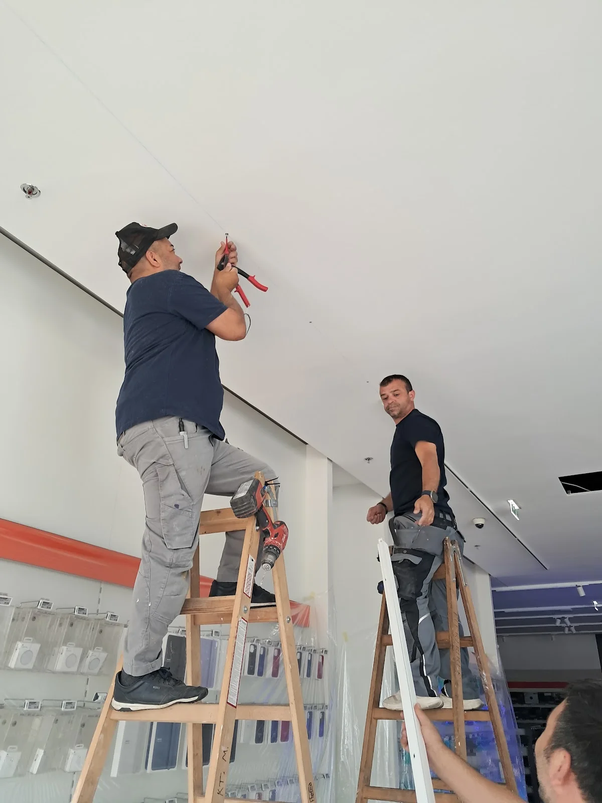 Zwei BM Mitarbeiter bei Elektro- und Lichtmontage im Innenraum